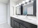 Bathroom with double sinks and a marble-look floor tile and dark vanity at 5808 Silver Moon Ave, Tampa, FL 33625