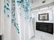 Well-lit bathroom with marble-look tile, dark vanity and shower with patterned curtain at 5808 Silver Moon Ave, Tampa, FL 33625