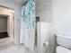 Bathroom featuring a toilet, shower with patterned curtain, and marble-look tile at 5808 Silver Moon Ave, Tampa, FL 33625