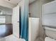 Bathroom showing a shower with a blue curtain, toilet, and an open door to the Primary bedroom at 5808 Silver Moon Ave, Tampa, FL 33625
