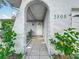 Home entrance featuring the address, arched entrance, tile pathway and lush landscaping at 5808 Silver Moon Ave, Tampa, FL 33625