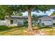 Charming single-story home with a well-manicured lawn, mature trees, and a two-car garage at 5808 Silver Moon Ave, Tampa, FL 33625