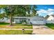 Charming single-story home with a well-manicured lawn, mature trees, and a two-car garage at 5808 Silver Moon Ave, Tampa, FL 33625