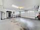 Clean, empty garage featuring a white door, concrete floor, and overhead storage for organized storage at 5808 Silver Moon Ave, Tampa, FL 33625