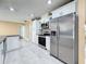 Bright kitchen showcases stainless steel appliances, granite countertops, and sleek, white cabinetry at 5808 Silver Moon Ave, Tampa, FL 33625