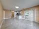 Open living room with tiled floors, flowing into the kitchen, and a glass sliding door at 5808 Silver Moon Ave, Tampa, FL 33625