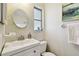 The bathroom features an oval mirror above the sink, complemented by stylish decor and a towel rack at 5825 Oakhurst Dr, Seminole, FL 33772