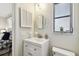 The bathroom features an oval mirror above the sink, complemented by stylish decor, lighting, and a view into bedroom at 5825 Oakhurst Dr, Seminole, FL 33772