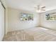This spacious bedroom features a ceiling fan, two windows, neutral walls, and carpeted floors at 5825 Oakhurst Dr, Seminole, FL 33772