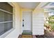 Elegant white front door with a welcome mat, decorative side window, and well-maintained exterior, adding charm at 5825 Oakhurst Dr, Seminole, FL 33772