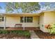 Inviting covered front porch with a bench, decorative plants, and a 'Welcome' mat, creating a warm entry at 5825 Oakhurst Dr, Seminole, FL 33772