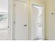 Bright hallway featuring white doors, neutral walls, and mixed flooring leading to bedrooms and other living spaces at 5825 Oakhurst Dr, Seminole, FL 33772