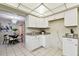 Bright kitchen with granite countertops, white cabinets, and view into the dining room area at 5825 Oakhurst Dr, Seminole, FL 33772