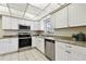 Modern kitchen with stainless appliances, white cabinets, granite countertops, and tiled floors at 5825 Oakhurst Dr, Seminole, FL 33772