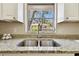 Close-up of kitchen sink featuring stainless steel sink, granite counter tops and a view out the window at 5825 Oakhurst Dr, Seminole, FL 33772