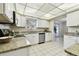 Well-lit kitchen featuring granite counters, stainless steel appliances, and white cabinetry at 5825 Oakhurst Dr, Seminole, FL 33772