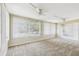 Spacious living room filled with sunlight with neutral walls, large windows and plush carpeting at 5825 Oakhurst Dr, Seminole, FL 33772