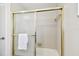 Shower stall with gold trim and glass doors with white tile in the interior at 5825 Oakhurst Dr, Seminole, FL 33772