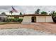 Charming single-story home featuring a brick driveway, landscaped yard, and American flag at 6409 41St N Ave, St Petersburg, FL 33709