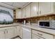 Cozy kitchen featuring classic cabinetry, countertops, and stylish backsplash details at 6409 41St N Ave, St Petersburg, FL 33709