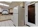 Bright kitchen featuring white appliances, tiled backsplash, and access to an exterior door at 6409 41St N Ave, St Petersburg, FL 33709