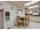 Cozy eat-in kitchen with white cabinetry, tiled floors, and a view to the living area at 6409 41St N Ave, St Petersburg, FL 33709