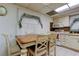 Kitchen dining area with a wood-topped table, white chairs, and kitchen appliances at 6409 41St N Ave, St Petersburg, FL 33709