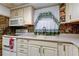 Kitchen with white cabinetry, a range, a microwave, neutral countertops, and decorative backsplash tiles at 6409 41St N Ave, St Petersburg, FL 33709