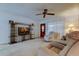 Bright living room with plush carpeting, fan, and a large entertainment center at 6409 41St N Ave, St Petersburg, FL 33709