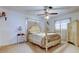 Main bedroom with a decorative, light colored four-poster bed, coordinating furniture, and bright windows at 6409 41St N Ave, St Petersburg, FL 33709