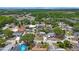 An aerial view of a neighborhood with tree-lined streets, diverse home styles, and a glimpse of green spaces at 6639 Winding Oak Dr, Tampa, FL 33625
