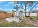 Backyard shed and patio area with trees that provide shade and a grill for outdoor enjoyment at 6639 Winding Oak Dr, Tampa, FL 33625