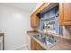 Galley kitchen featuring stainless steel sink and faucet and light wood cabinets at 6639 Winding Oak Dr, Tampa, FL 33625