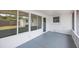 Enclosed outdoor patio with screened windows and painted concrete floors at 6639 Winding Oak Dr, Tampa, FL 33625