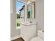 A compact bathroom features a marble vanity with a gold faucet and a wall-mounted mirror at 710 W Plymouth St, Tampa, FL 33603