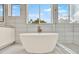 Modern bathroom with a sleek white tub, stylish tile, and large window offering natural light at 710 W Plymouth St, Tampa, FL 33603