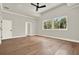 This neutral bedroom features hardwood floors, a ceiling fan, two windows, and a bright and airy feel at 710 W Plymouth St, Tampa, FL 33603