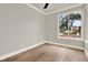Cozy bedroom featuring hardwood floors, a large window with a neighborhood view, and fresh paint at 710 W Plymouth St, Tampa, FL 33603