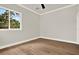 Bedroom featuring hardwood floors, natural light, ceiling fan, and views of the surrounding trees at 710 W Plymouth St, Tampa, FL 33603