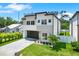 Stunning two-story home featuring a modern design, lush landscaping, and a sleek garage door at 710 W Plymouth St, Tampa, FL 33603