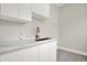 Bright laundry room with white cabinets, marble countertops, and modern bronze faucet at 710 W Plymouth St, Tampa, FL 33603