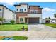 Modern two-story home featuring mixed-material facade, well-maintained lawn, and contemporary garage door for enhanced curb appeal at 712 W Plymouth St, Tampa, FL 33603