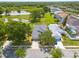 Aerial view of a home with a pond and beautiful surroundings including mature trees and lush green spaces at 7157 Hamilton Park Blvd, Tampa, FL 33615