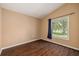 Neutral bedroom featuring wood-look floors, large window with ample natural light, and simple decor at 7157 Hamilton Park Blvd, Tampa, FL 33615