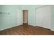 Bedroom with wood-look floors, closet, and light green walls, providing a comforting space at 7157 Hamilton Park Blvd, Tampa, FL 33615