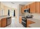 Well-lit kitchen features stainless appliances and wood cabinets at 7157 Hamilton Park Blvd, Tampa, FL 33615