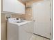 Well-lit laundry room equipped with modern washer and dryer, cabinets, and shelving for organization at 7157 Hamilton Park Blvd, Tampa, FL 33615