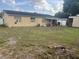 A spacious backyard with grass area, covered patio, and exterior home features at 7206 Reindeer Rd, Tampa, FL 33619
