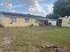 Large backyard with grass area, a covered patio, and view of the exterior of the home at 7206 Reindeer Rd, Tampa, FL 33619