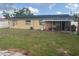 The backyard offers a large grass area and exterior home view at 7206 Reindeer Rd, Tampa, FL 33619